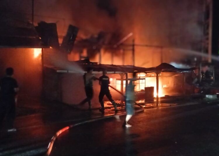 Petugas damkar memadamkan api yang membakar dua ruko di Jorong Simpang Empat, Nagari Lingkuang Aua, Kecamatan Pasaman, Pasaman Barat, pada Senin (18/5/2026) tengah malam. Foto: Irfansyah Pasaribu