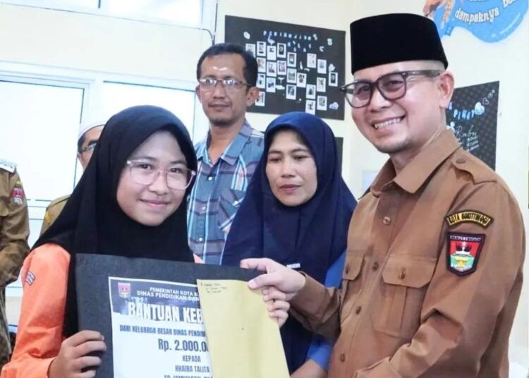 Wakil Wali Kota Bukittinggi, Ibnu Asis, menyerahkan bantuan kepada 15 pelajar dan seorang guru yang menjadi korban kebakaran di SMPN 2 Bukittinggi, Selasa (19/5).