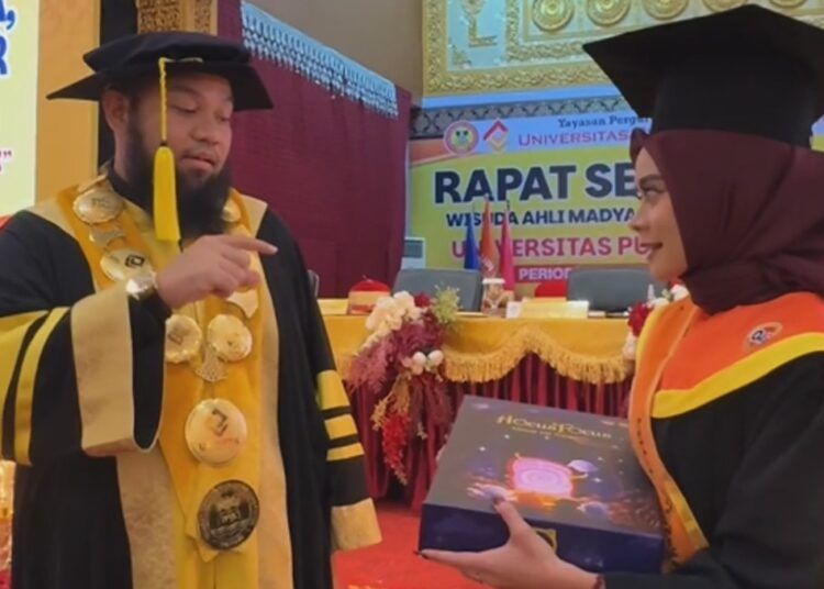 Rektor UPI YPTK Padang membeli tugas akhir wisudawan setelah acara wisuda periode II tahun akademik 2025/2026 Universitas Putra Indonesia (UPI) YPTK Padang di UPI Convention Center pada Kamis (21/5/2026).