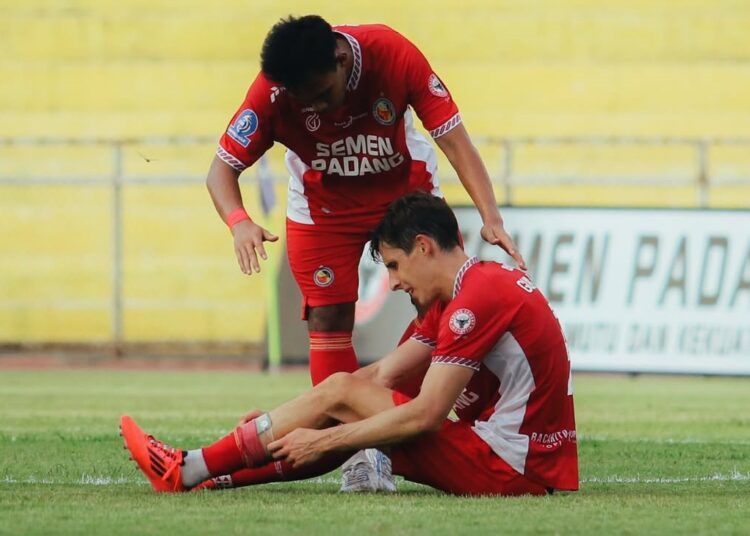 Pemaian Semen Padang FC membenahi kaus kakinya dalam suatu pertandingan beberapa waktu yang lalu. Foto: Instagram Semen Padang FC