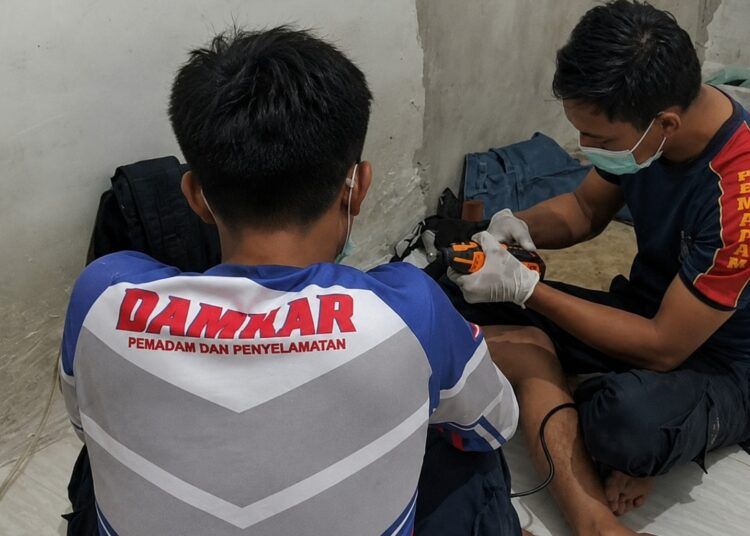 Personel Dinas Pemadam Kebakaran dan Penyelamatan (Damkarmat) Kota Dumai, Riau, saat mengevakuasi cincin logam yang tersangkut pada organ intim seorang pria berusia sekitar 21 tahun, Minggu (19/7/2026). IST