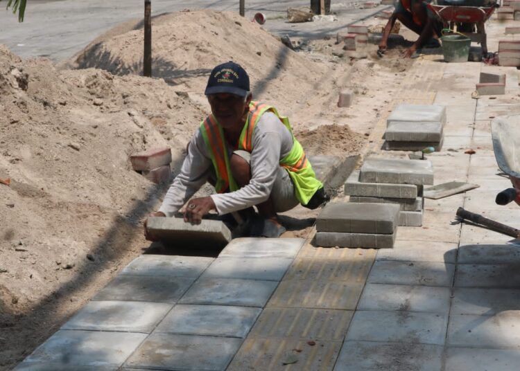 Pekerja menyelesaikan pembangunan trotoar di salah satu ruas jalan protokol Kota Padang. Proyek ini menjadi bagian dari program Padang Rancak untuk menghadirkan jalur pedestrian yang lebih aman dan nyaman bagi masyarakat.
