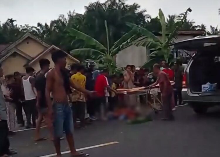 Petugas dan warga mengevakuasi korban kecelakaan yang melibatkan sepeda motor dan truk tangki di kawasan Simpang Cacang, Durian Kapeh, Lubuk Basung, Kabupaten Agam, Sabtu (4/7/2026) sore