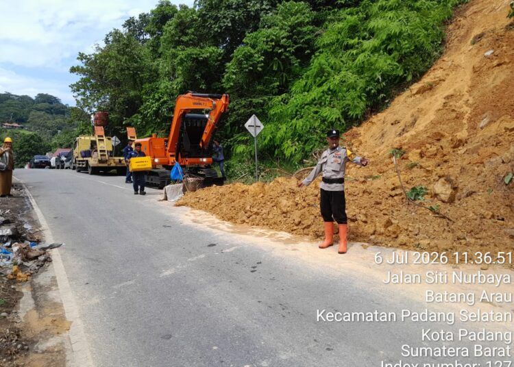 Alat berat milik DPUPR Kota Padang membersihkan material longsor yang menutupi sebagian badan jalan di kawasan Gunung Padang, Kelurahan Batang Arau, hingga arus lalu lintas kembali normal.