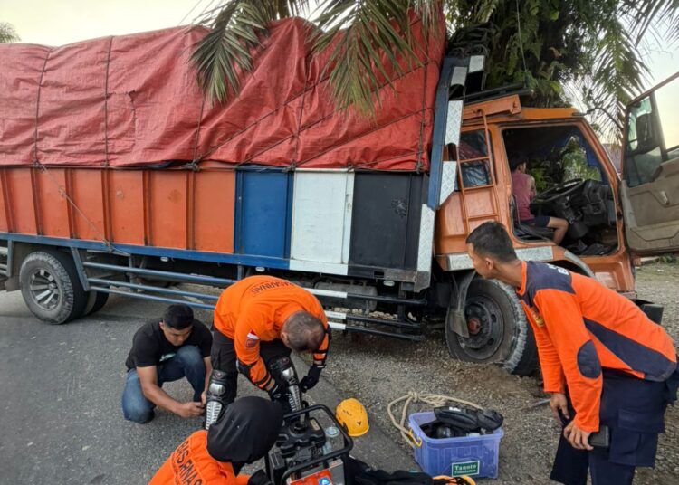 Sebuah truk fuso bermuatan karet menabrak pohon sawit di Jalan Raya Simpang Empat Aia Gadang, Kecamatan Pasaman, Kabupaten Pasaman Barat, Sumatera Barat, Rabu (8/7/2026).