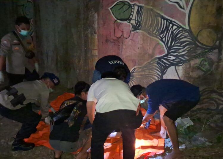 Petugas kepolisian mengevakuasi jenazah pria tanpa identitas yang ditemukan di bawah flyover kawasan Bandara Internasional Minangkabau (BIM), Nagari Kasang, Kecamatan Batang Anai, Kabupaten Padang Pariaman, Rabu (8/7/2026) sore.