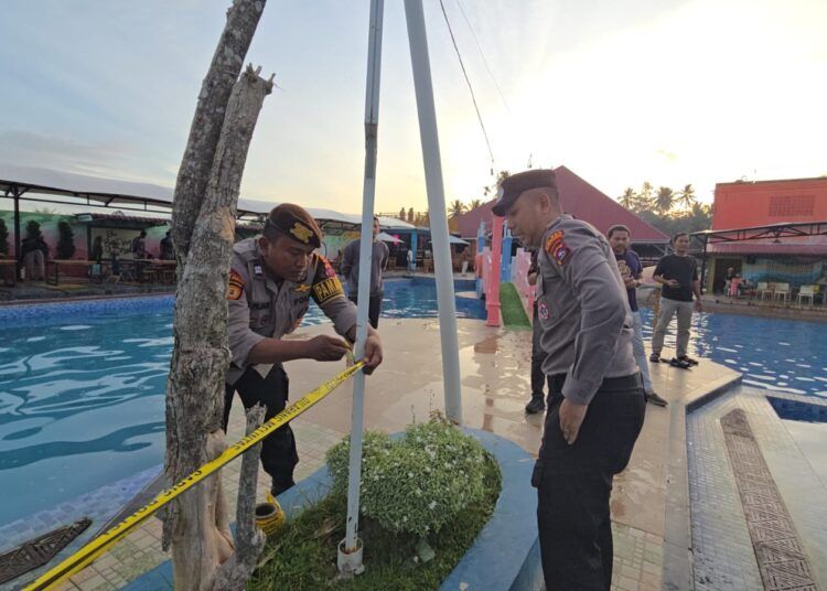 Petugas kepolisian memasang garis polisi di area kolam pemandian yang menjadi lokasi seorang bocah berusia lima tahun meninggal dunia akibat tenggelam di Kecamatan 2x11 Enam Lingkuang, Kabupaten Padang Pariaman, Sabtu (11/7/2026).
