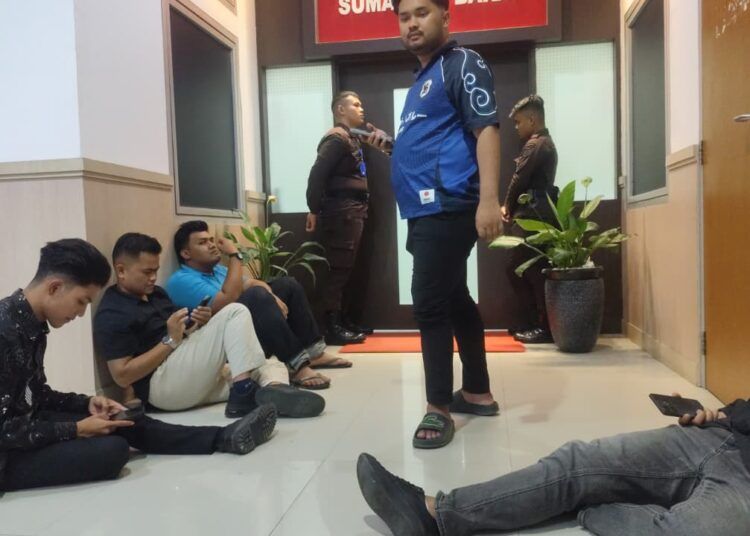 Beberapa aktivis mahasiswa menunggu rekannya, Fadil Ramadhan, keluar dari ruangan Kepala Kejati Sumbar pada Minggu (12/7/2026) malam.