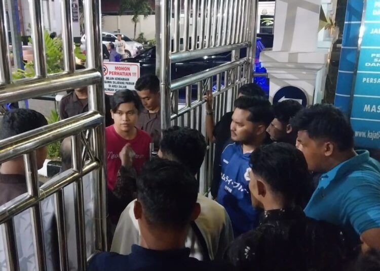 Mahasiswa UIN Imam Bonjol sekaligus aktivis aliansi OKP Sumbar Menggugat, Fadil Ramadhan, keluar dari Gedung Kejati Sumbar pada Minggu (12/7/2026) malam setelah diinterogasi sejak siang. Foto: Mengki Kurniawan/Kabarminang.com