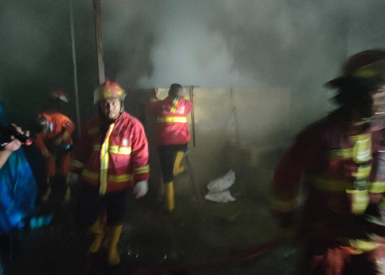 Petugas Dinas Pemadam Kebakaran Kota Padang memadamkan api yang membakar gudang pengolahan kopra di Jalan Seberang Padang, Kecamatan Padang Selatan, Selasa (14/7/2026) petang.