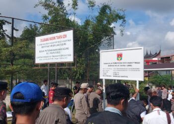 Personel Satpol PP bersama aparat gabungan memasang plang pengamanan aset Pemerintah Kota Bukittinggi di kawasan Universitas Fort De Kock, Rabu (22/7/2026).