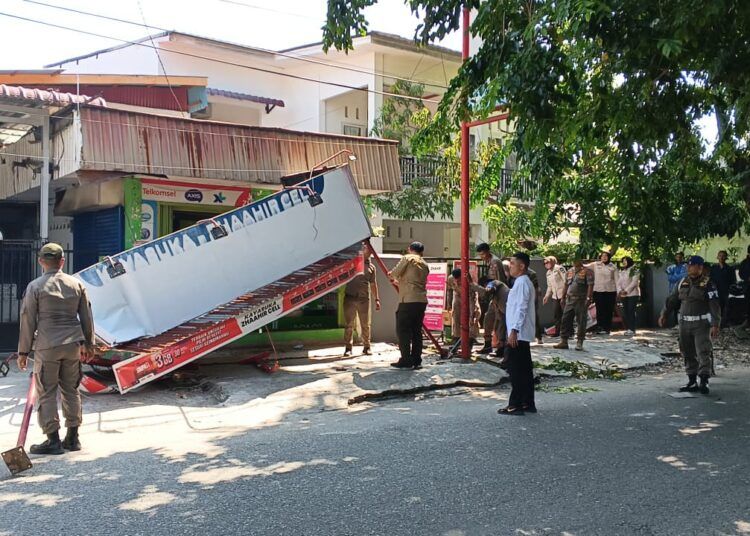 Petugas Satuan Polisi Pamong Praja (Satpol PP) Kota Padang membongkar kanopi sebuah bangunan yang memanfaatkan trotoar sebagai bagian dari area bangunan di kawasan Jalan Taduah Jati, Kecamatan Padang Barat, Jumat (31/7/2026).