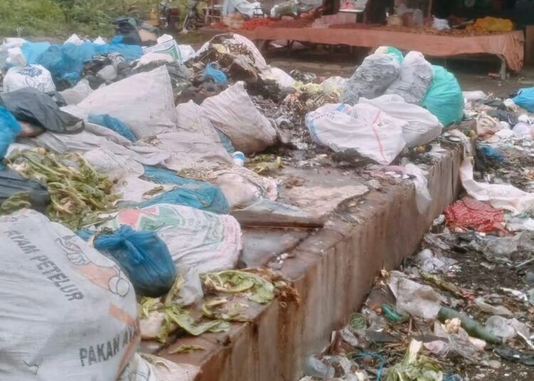Tumpukan sampah membusuk menggunung di area belakang Pasar Simpang Empat, Nagari Lingkuang Aua, Kecamatan Pasaman, Kabupaten Pasaman Barat, Jumat (31/7/2026).