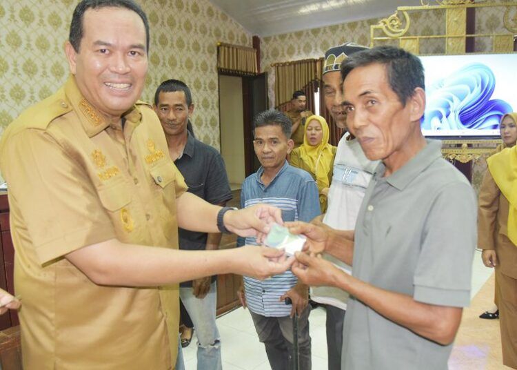 Wali Kota Pariaman, Yota Balad, menyerahkan secara simbolis kartu BPJS Ketenagakerjaan kepada 2.897 pekerja rentan di Kota Pariaman di Aula Lantai III Kantor Bersama Karan Aur, Senin (10/8/2026).