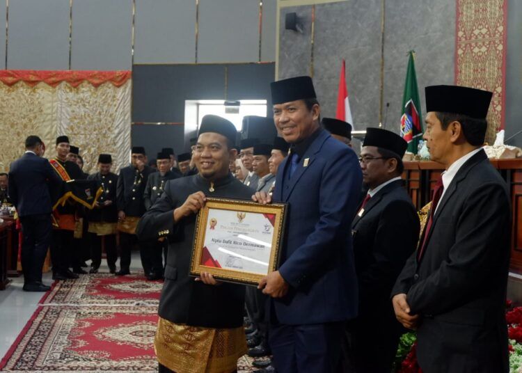Aiptu Dafit Rico Dermawan atau yang lebih dikenal masyarakat sebagai David Wewe menerima piagam penghargaan dan pin emas dari Pemerintah Kota Padang pada Rapat Paripurna Istimewa DPRD Kota Padang dalam rangka Hari Jadi ke-357 Kota Padang, Jumat (7/8/2026).