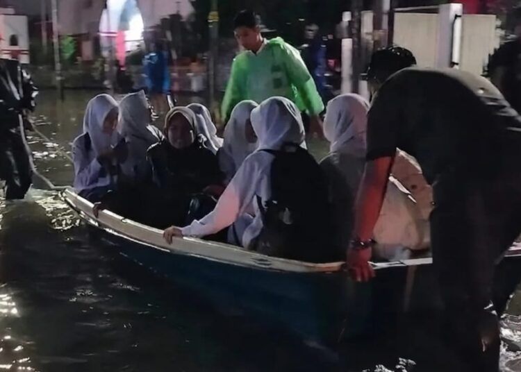 Sejumlah siswa SMAN 3 Padang dievakuasi menggunakan perahu akibat banjir yang merendam ruas Jalan Gunung Pangilun hingga Simpang Lampu Alai, Senin (3/8/2026).