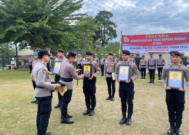 Kepala Polres Sijunjung, AKBP Willian Harbensyah, mencoret foto keempat polisi dengan spidol sebagai simbol pemecatan dalam upacara PTDH di lapangan upacara polres setempat pada Selasa (4/8/2026). Foto: Polres Sijunjung