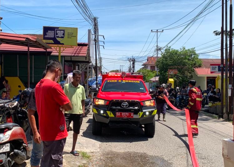 Petugas Dinas Pemadam Kebakaran Kota Padang berupaya memadamkan api yang melalap sebuah minimarket di Jalan Belibis, Kelurahan Air Tawar Barat, Kecamatan Padang Utara, Rabu (5/8/2026).