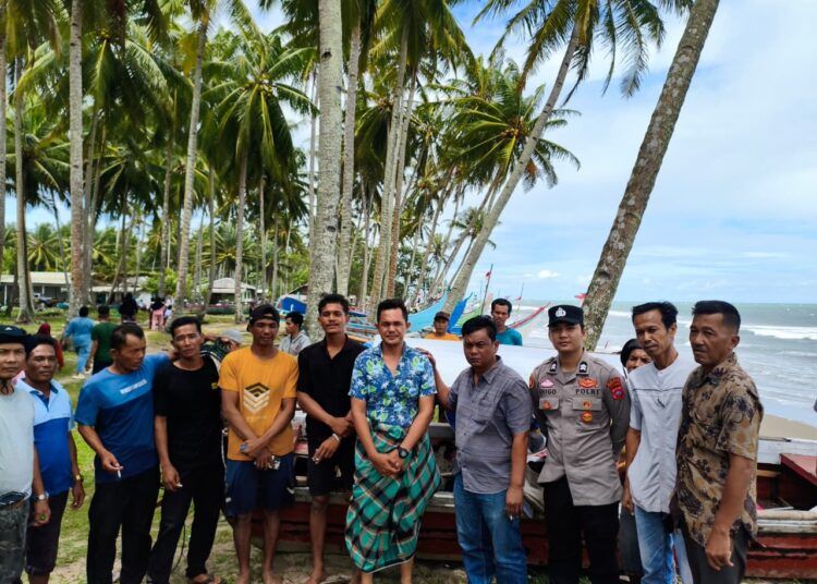 Polisi bersama nelayan setempat dan Aidil Helmi (mengenakan kain sarung), warga Pagaruyung I, Painan, Kabupaten Pesisir Selatan, Sumatera Barat, yang ditemukan selamat setelah terombang-ambing di laut selama lebih dari satu hari usai kapal boat yang digunakannya rusak akibat diterjang badai saat memancing. Foto: Polsek Lengayang