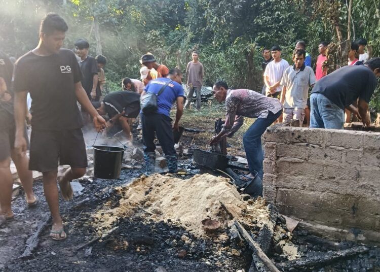 Petugas Damkar Pesisir Selatan bersama warga berupaya memadamkan kebakaran yang menghanguskan rumah semi permanen di Kampung Akad, Nagari Kambang Utara, Kecamatan Lengayang, Jumat (7/8/2026) sore.