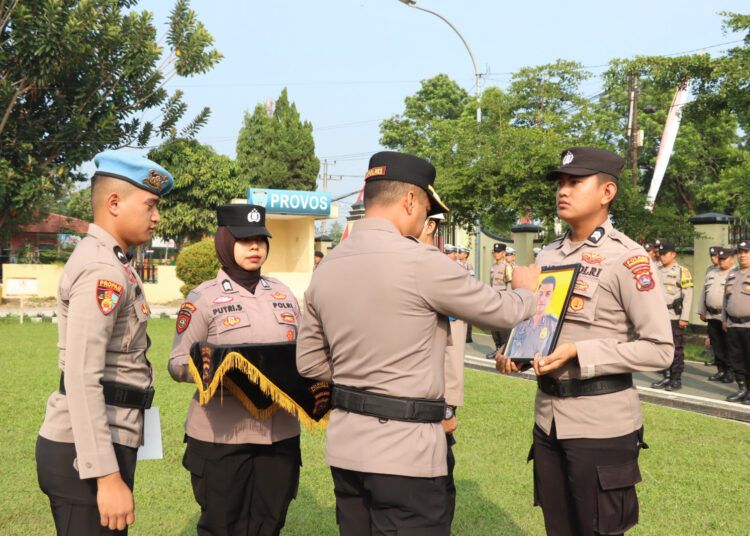 Kepala Polres Payakumbuh, AKBP Irwan Andeta, menyilang foto dua polisi yang dipecat dalam upacara PTDH di lapangan upacara polres setempat pada Rabu (12/8/2026). Foto: Polres Payakumbuh