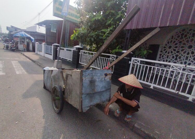Budi Kuncoro (59), pemulung di Kota Padang, mendorong gerobak buatannya saat mengumpulkan barang bekas di kawasan Alai Parah Kopi, Kecamatan Padang Utara, Rabu (12/8/2026).