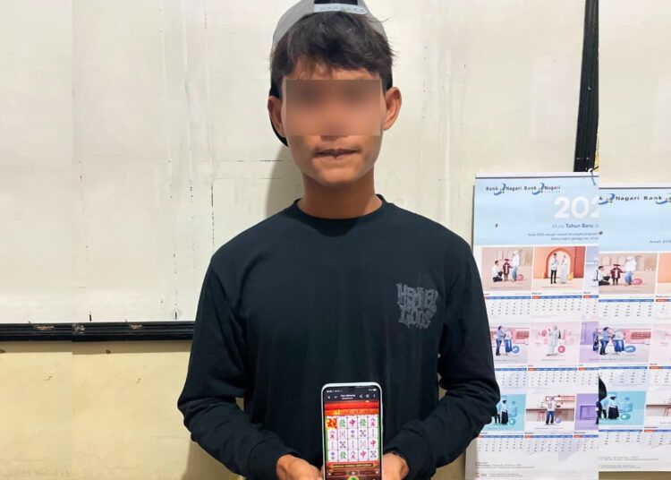 Polisi menangkap pemuda berinisial AA (22) saat bermain judi online jenis slot di sebuah warung kawasan Pasar KTM Silaut, Nagari Lubuk Bunta, Kecamatan Silaut, Kabupaten Pesisir Selatan, pada Jumat (21/8/2026) dini hari. Foto: Polsek Lunang Silaut