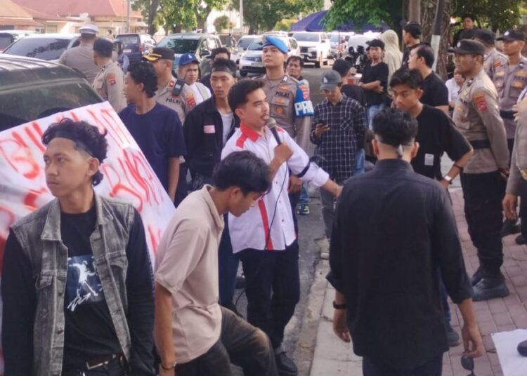 massa menggelar aksi di depan kantor Perumda Air Minum Kota Padang di kawasan Sawahan, Kecamatan Padang Timur, Senin (24/8/2026), sambil membawa spanduk bertuliskan “Kami Butuh Air Bersih”.