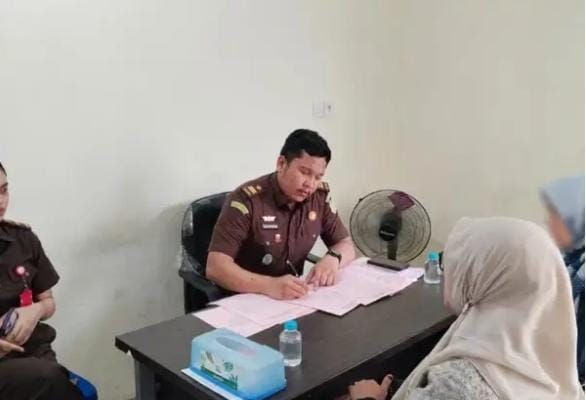 Tersangka dugaan korupsi pengelolaan keuangan Nagari Koto Baru, Kabupaten Solok, berinisial M saat menjalani tahap II di Kejari Solok, Senin (24/8/2026).