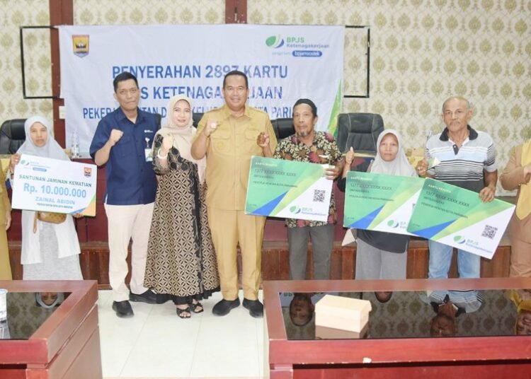 Wali Kota Pariaman Yota Balad menyerahkan secara simbolis kartu BPJS Ketenagakerjaan kepada 154 pekerja rentan melalui Program Tuwai Ketan di Aula Lantai III Kantor Bersama Karan Aur, Kota Pariaman, Selasa (15/9/2026).