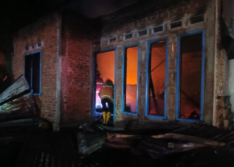 Petugas gabungan memadamkan api yang membakar dua unit rumah di Jorong Tabek Akiang, Nagari Tanjuang Bonai, Kecamatan Lintau Buo Utara, Kabupaten Tanah Datar, Senin (7/9/2026) malam.
