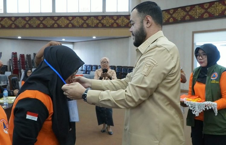 Wali Kota Padang, Fadly Amran, mengalungkan kokarde peserta pelatihan Kelompok Siaga Bencana di di Convention Hall Bukit Lampu pada Senin (21/9/2026). Foto: Pemko Padang