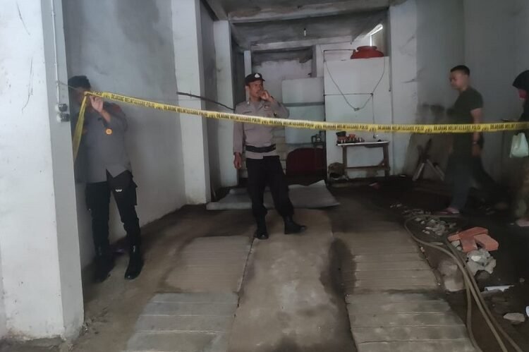 Polisi memasang garis polisi di rumah tempat penemuan mayat di rumahnya di RT 01, RW 01, Kelurahan Kubang Sirakuk Selatan, Kecamatan Lembah Segar, Sawahlunto, Sumatera Barat, pada Selasa (22/9/2026) siang. Foto: Polsek Sawahlunto