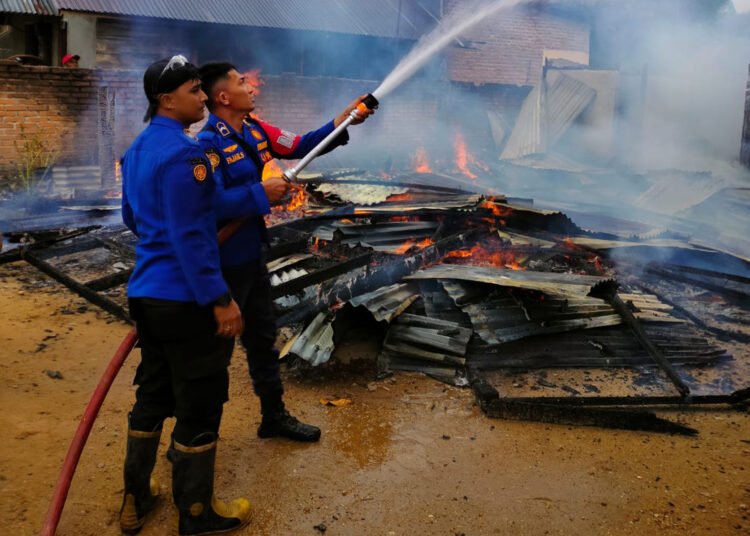 Petugas pemadam kebakaran memadamkan api yang menghanguskan sebuah rumah di Jorong Ketinggian, Nagari Sarilamak, Kecamatan Harau, Kabupaten Lima Puluh Kota, Sabtu (26/9/2026).