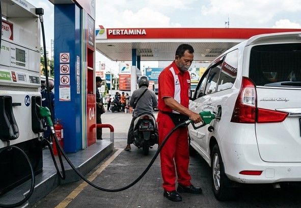 Seorang petugas SPBU mengisikan Pertalite ke tangki mobil. Ilustrasi: Gemini AI