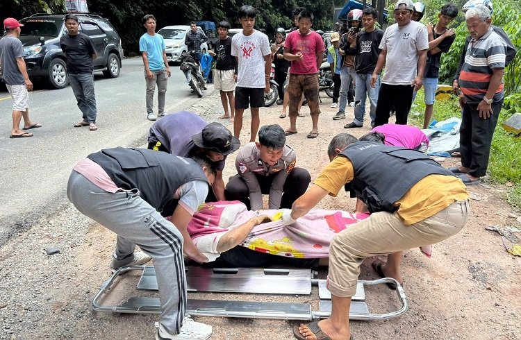 Petugas kesehatan dan polisi menaruh sopir truk ke dalam tandu untuk dibawa ke RSUD Adnaan WD Payakumbuh setelah terlindas truknya sendiri di Jalan Nasional Lintas Sumbar—Riau KM 21, Jorong Aia Putiah Lubuak Bangku, Nagari Sarilamak, Kecamatan Harau, Lima Puluh Kota, pada Minggu (20/9/2026) siang. Foto: Polres 50 Kota