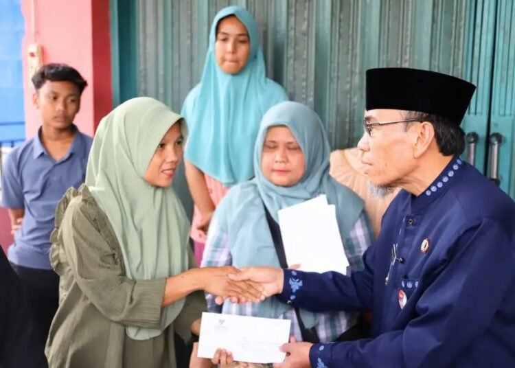 Wakil Wali Kota Padang, Maigus Nasir, menyerahkan bantuan tunai dari Badan Amil Zakat Nasional (Baznas) Kota Padang kepada masing-masing keluarga terdampak, Selasa (13/10/2026).