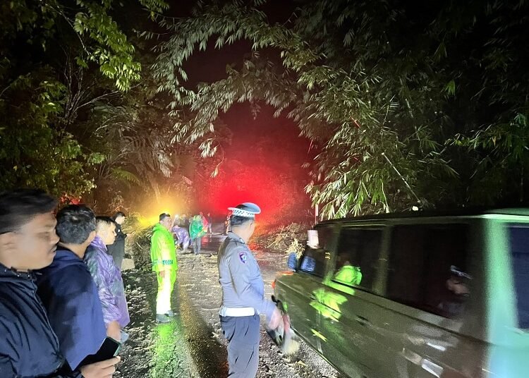 Polisi mengatur arus lalu lintas di Jalur lintas Padang Panjang–Batusangkar sempat lumpuh total selama kurang lebih satu jam akibat tanah longsor dan pohon tumbang yang menimbun badan jalan pada Kamis (1/10/2026) malam. Foto: Polres Padang Panjang