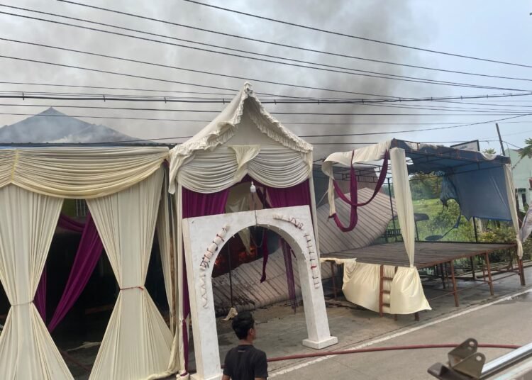 Tenda pesta pernikahan yang telah terpasang di lokasi tampak berada di sekitar rumah dan toko yang terbakar di Jorong Subarang Koto Panjang, Nagari Pangkalan, Kecamatan Pangkalan Koto Baru, Kabupaten Lima Puluh Kota, Minggu (4/10/2026).