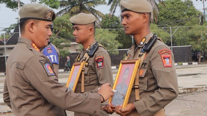 Kepala Satpol PP Kota Padang, Chandra Eka Putra, mencoret foto lima personel yang dipecat dalam Upacara Pemberhentian Tidak dengan Hormat pada Senin (5/10/2026). Foto: Satpol PP Padang