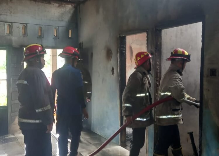 Petugas melakukan pemadaman rumah yang terbakar di Jorong Simpang Empat Kabindu, Nagari Labuh Gunung, Kecamatan Lareh Sago Halaban, Kabupaten Lima Puluh Kota, Jumat (9/10/2026).