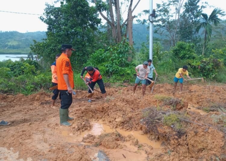 Sejumlah orang membersihkan material longsor yang menimbun badan jalan di kawasan wisata Mandeh kilometer 59, Kabupaten Pesisir Selatan, Sumatera Barat, pada Sabtu (10/10/2026) sekitar pukul 08.00 WIB.