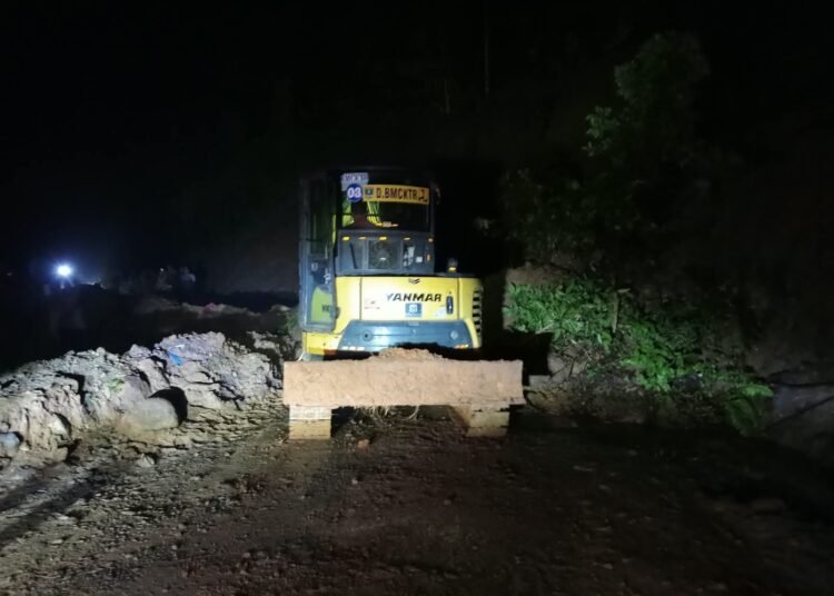 Petugas bersama alat berat membersihkan material longsor yang menutupi ruas jalan Padang Koto Gadang–Matur di Labuah Sampik, Jorong Ngungun, Nagari Salareh Aia, Kecamatan Palembayan, Kabupaten Agam, Minggu (18/10/2026). Foto: BPBD Kabupaten Agam