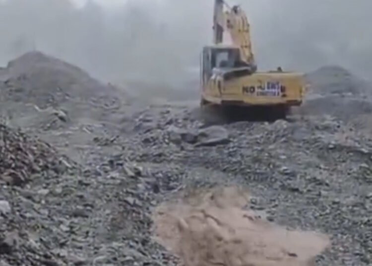Satu unit ekskavator melakukan normalisasi aliran sungai di kawasan bekas bencana Nagari Sungai Batang, Kabupaten Agam, Senin (19/10/2026), saat hujan deras dan debit air meningkat akibat cuaca ekstrem.
